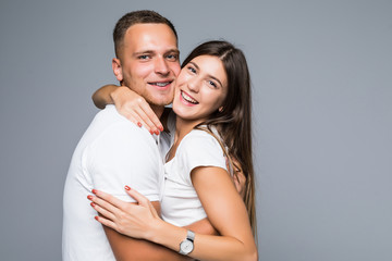 Portrait of happy couple looking at camera against gray background