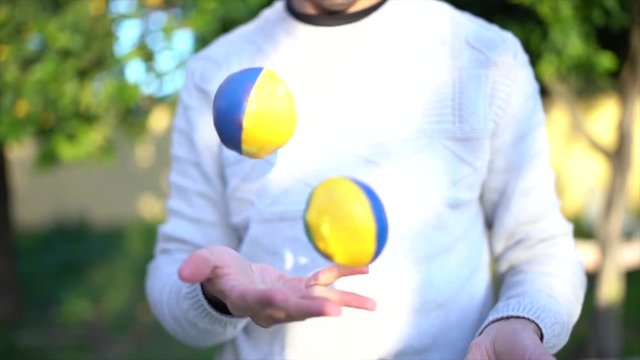 A young man juggling in the garden