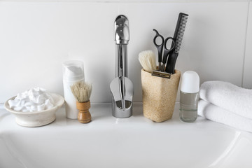 Shaving accessories with cosmetics for men on sink in bathroom