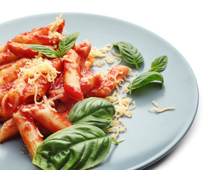 Plate with tasty penne pasta on white background