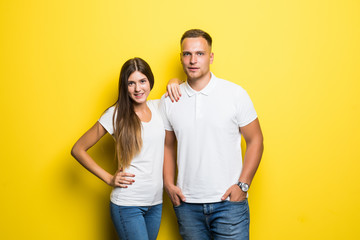 Fototapeta premium Portrait of happy lovely couple smiling and posing on camera together over yellow background