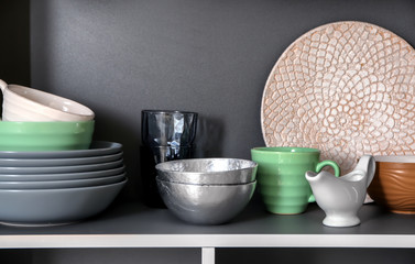 Set of clean tableware on shelf