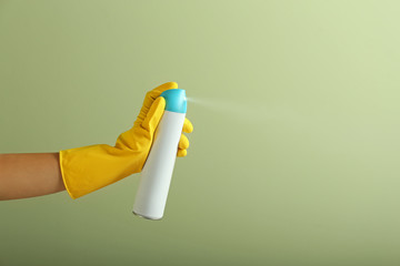 Woman spraying air freshener on color background