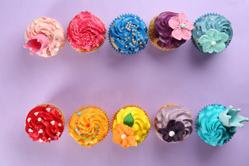 Delicious cupcakes on color background