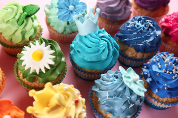 Delicious cupcakes on color background