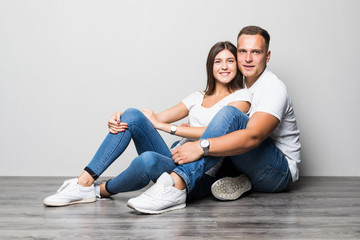 Fototapeta na wymiar Beautiful couple in love on white background dressed in blue jeans and white undershirt