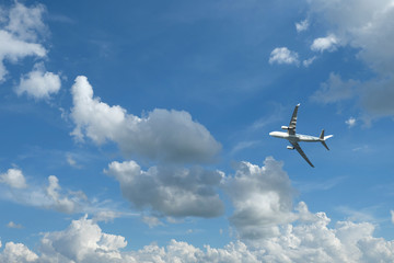 Airplane flying in blue sky and clouds