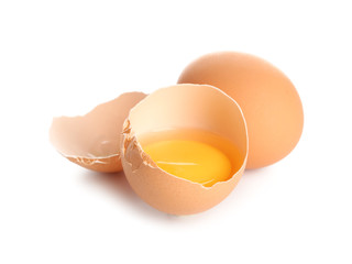 Cracked and whole chicken eggs on white background