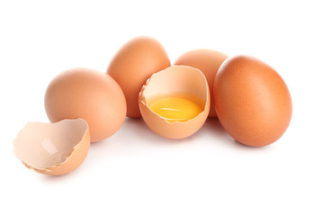 Cracked and whole chicken eggs on white background