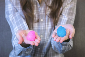 Two slimes pink and blue in woman's hands. Playing with slime.