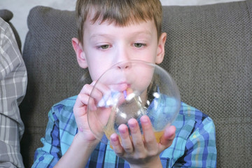 Boy inflates a big bubbles from a slimes. Play with slime.