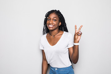 Close up portrait of a happy young woman with peace sign isolated on gray background