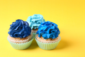 Tasty cupcakes on color background
