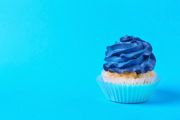 Tasty cupcake on color background