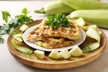 Plate with tasty squash waffles on wooden plate