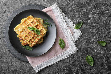 Plate with tasty squash waffles on grey table