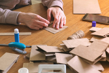 Woman makes a bag for christmas advent calendar from kraft paper.