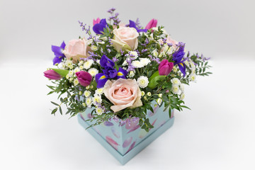 Delicate bouquet of flowers (roses, tulips, irises) in a box