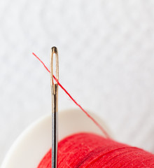 Thread the needle . Needle for sewing Red spool .