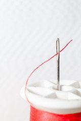 Thread the needle . Needle for sewing Red spool .