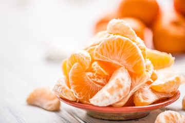 Fresh pieces of tangerines mandarin on the plate or in a bowl