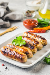 Grilled sausages with sauce vegetables and herbs. Selective focus, space for text.