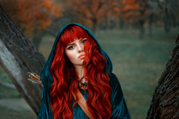 attractive red-haired girl looking at the camera with brown eyes, wearing blue velor velvet cloak...