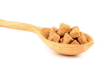 Brown Unrefined Single Evaporated Demerara Cane Sugar Cube Chunk Pieces in Wooden Spoon, Isolated on White Background.