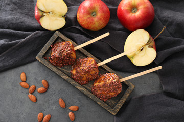 Sticks with candy apple wedges on grey table