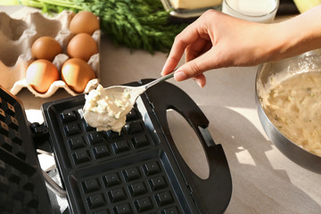 Woman preparing waffles in modern maker