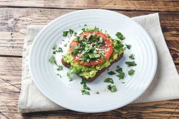 Avocado toast. Healthy toast with avocado mash and tomatoes on a plate.
