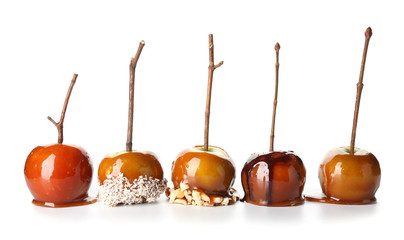 Delicious caramel apples with tree branches on white background