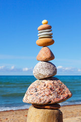 Fototapeta na wymiar Gray and red zen stones on the background of the sea. Concept of harmony, balance and meditation.