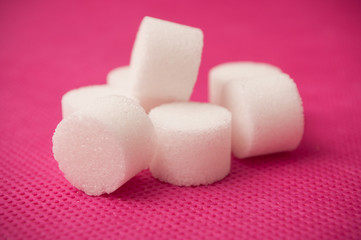 Obraz na płótnie Canvas closeup of sugar in shaped circle on pink background