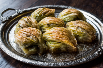 Turkish Midye Baklava ( Mussel Shape Baklawa ) with green pistachio Powder and Butter Cream in Silver Tray.