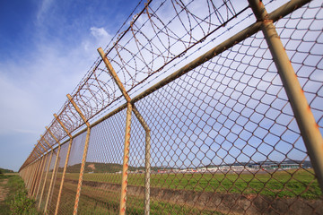 Obraz premium Metal fence wire, War and sky in the background in Phuket Thailand