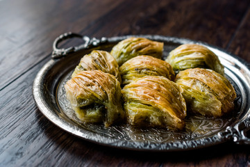 Turkish Midye Baklava ( Mussel Shape Baklawa ) with green pistachio Powder and Butter Cream in Silver Tray.