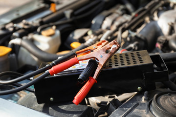 Fototapeta na wymiar Battery charger under open hood of car