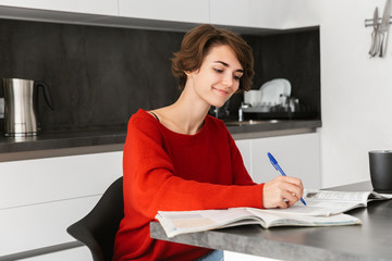 Smiling young woman studying at the table