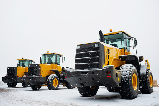 Yellow Wheel Front Loaders. Construction And Handling Equipment. Heavy Diesel Tractor, Construction Machinery, Industrial Vehicle. Winter Time