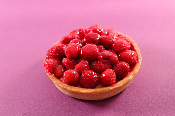 raspberry tart on pink background