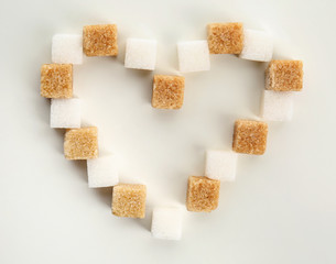 Heart made with different cubes of sugar on white background