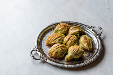Turkish Midye Baklava ( Mussel Shape Baklawa ) with green pistachio Powder and Butter Cream in Silver Tray.