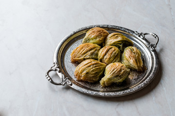 Turkish Midye Baklava ( Mussel Shape Baklawa ) with green pistachio Powder and Butter Cream in Silver Tray.