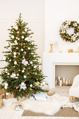 Christmas decor. Bright cozy living room in white with a large beautiful Christmas tree