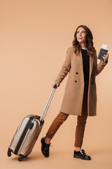 Full length of a smiling young woman wearing a coat walking