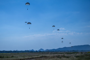 Jump of paratrooper with white parachute, Military parachute jumper in the sky.