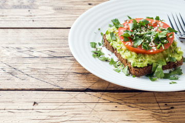 Avocado toast. Healthy toast with avocado mash and tomatoes on a plate.