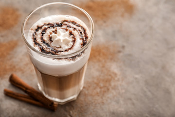 Glass of tasty aromatic latte on grey table
