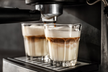 Coffee machine making latte, closeup